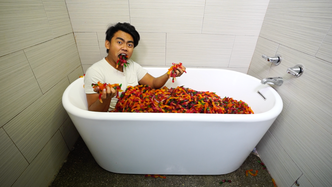 Man in bath tub full of gummy worms.