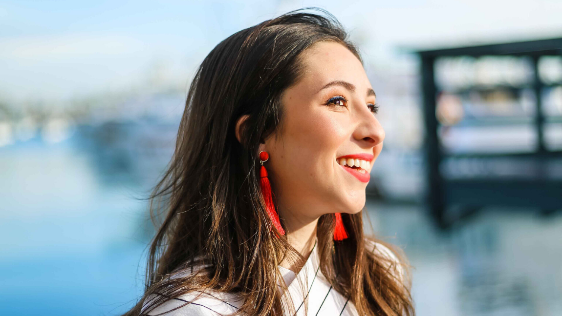 Woman smiling and looking out across the water.